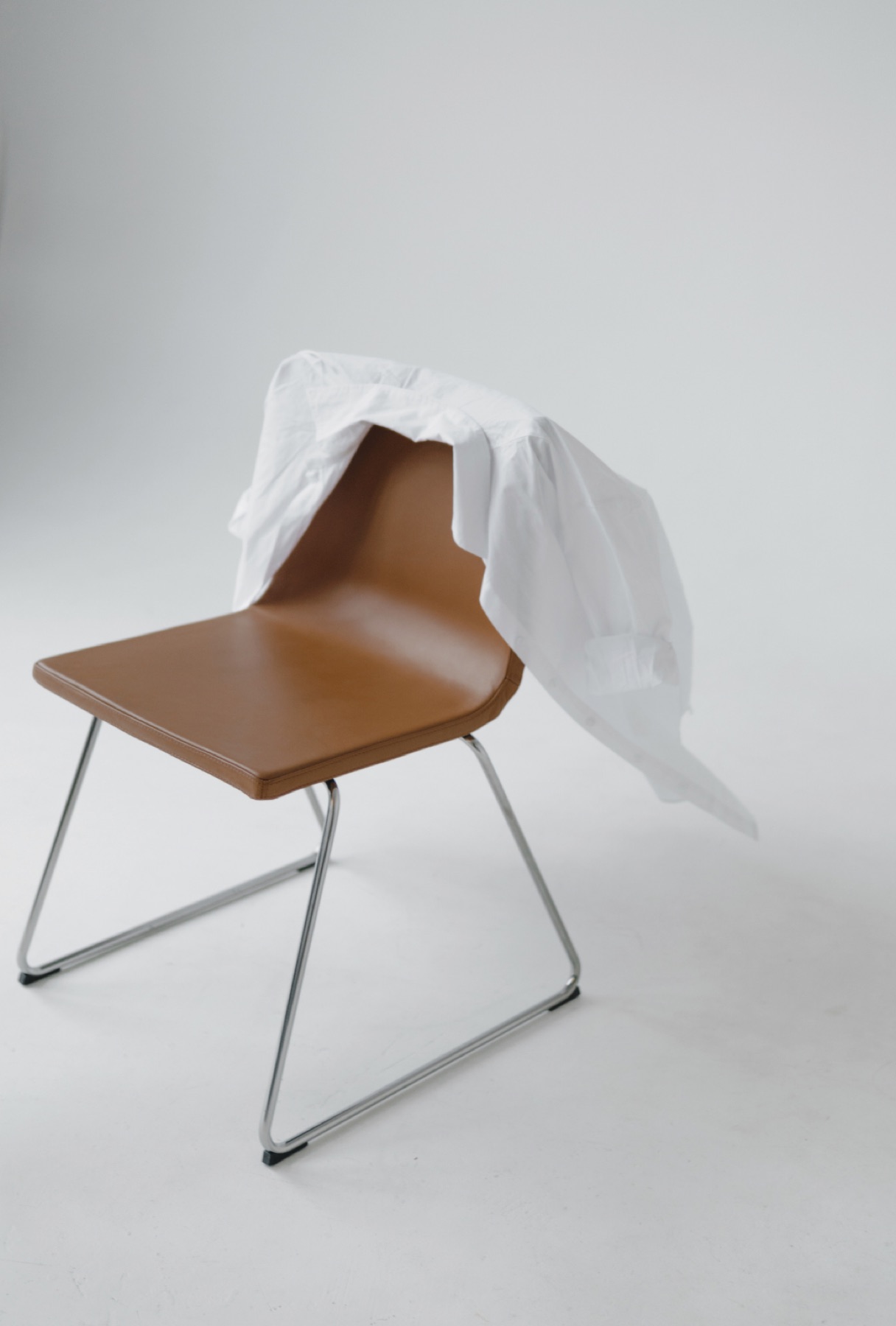 A wooden chair with a white cloth draped over it